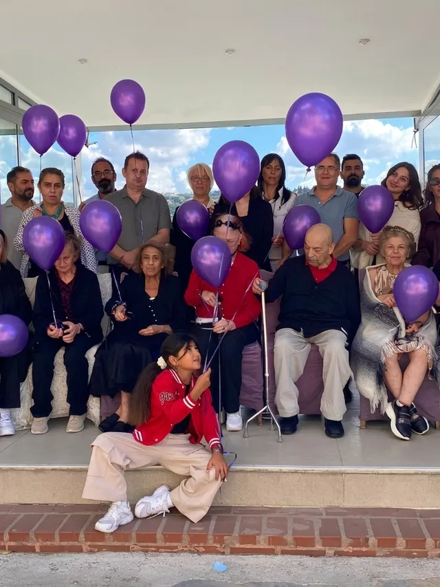 GAYA Huzurevi sakinleri ve ekibi, mor balonlarla Alzheimer farkındalık etkinliğinde bir arada